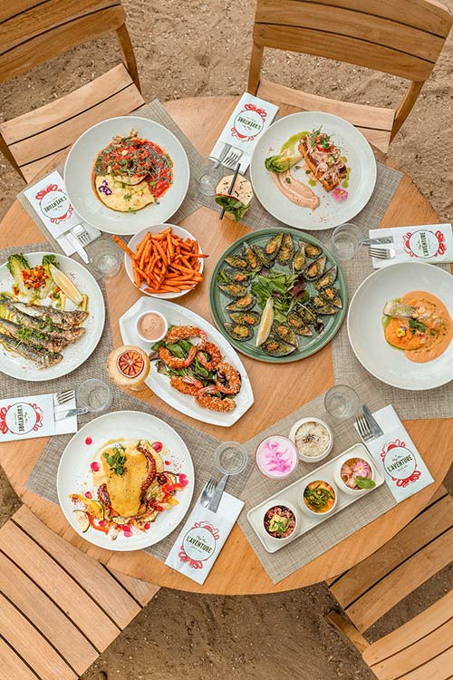 Repas de groupe en terrasse au restaurant L'Aventure à Carqueiranne — plateau de partage, fruits de mer et spécialités méditerranéennes pour un événement privatisé