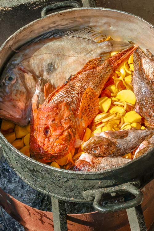 Marmite de bouillabaisse au feu de bois avec chapon, poissons de roche et pommes de terre — cuisson traditionnelle au restaurant L'Aventure, Carqueiranne