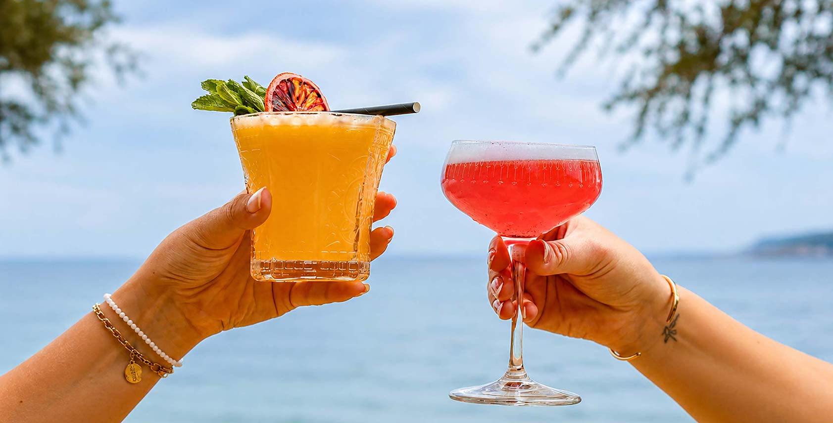 Deux cocktails levés face à la mer sur la terrasse du restaurant L'Aventure à Carqueiranne — bar de plage bord de mer, plage Péno