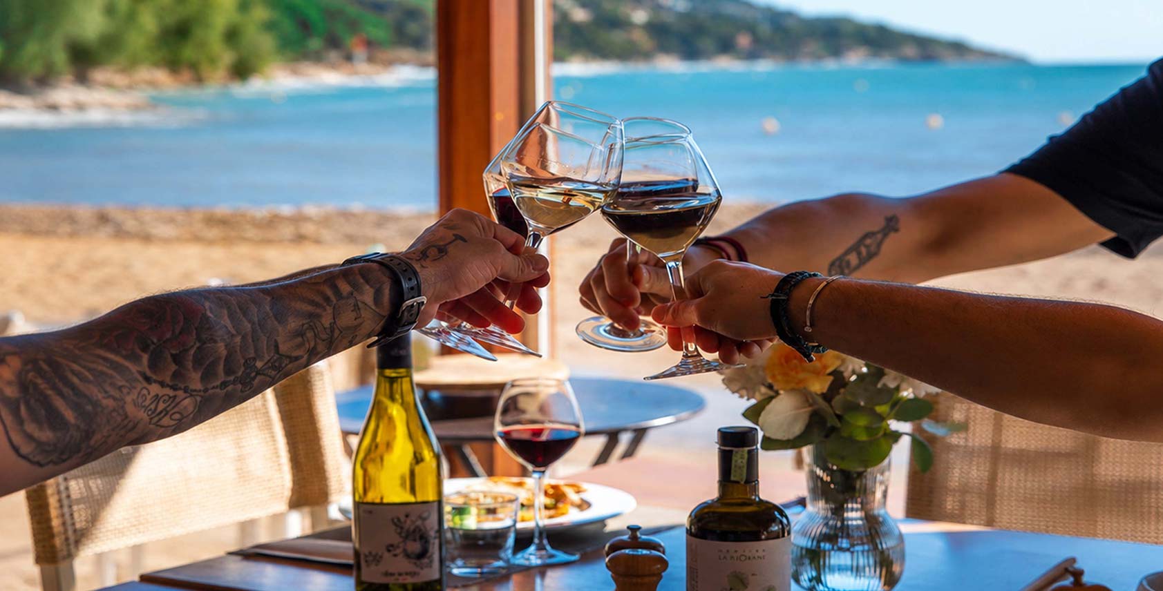 Trinquet de verres de vin blanc, rouge et rosé face à la mer sur la terrasse du restaurant L'Aventure à Carqueiranne — carte des vins de Provence